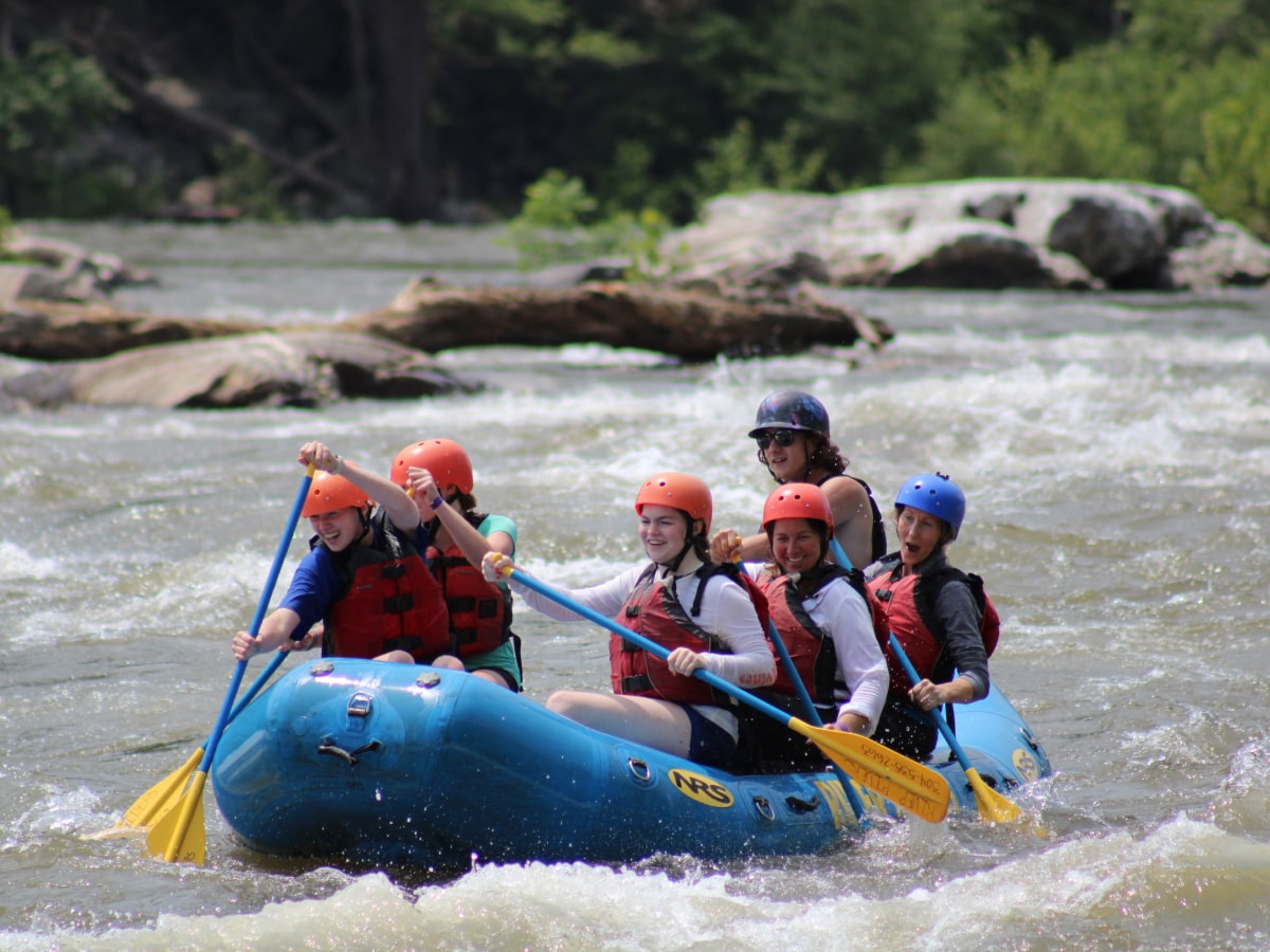 group of rafters paddling down white water section of the river