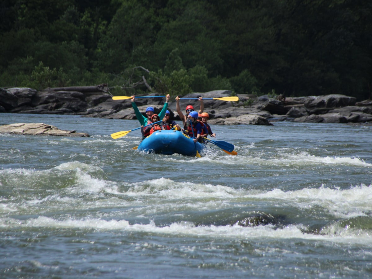 group of rafters paddling down white water section of the river