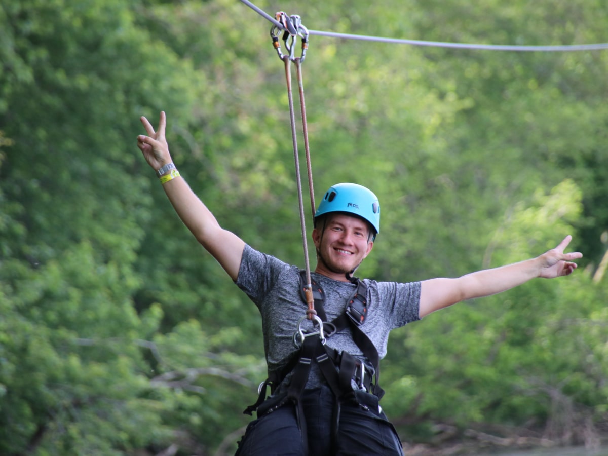 male on zipline with arms spread
