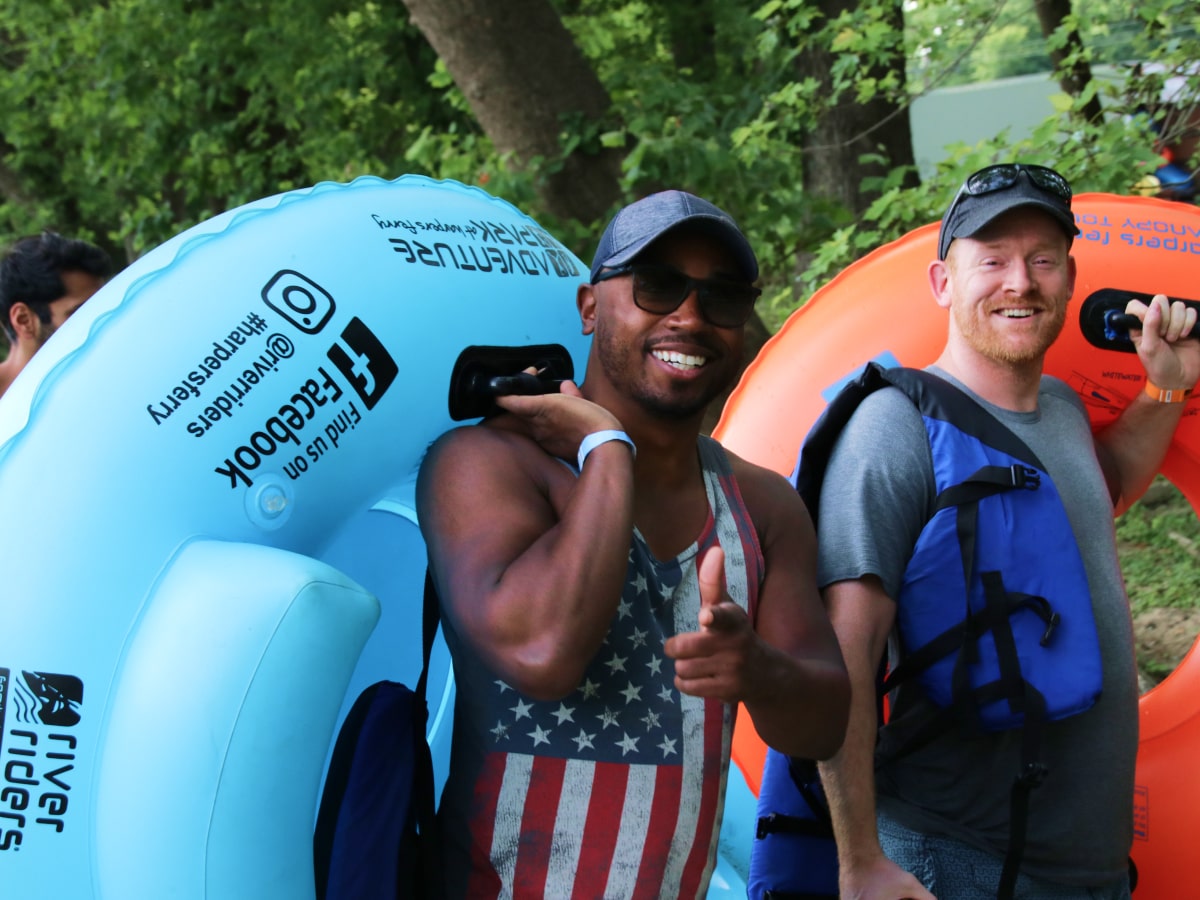two males carry tubes before tubing on the shenandoah river