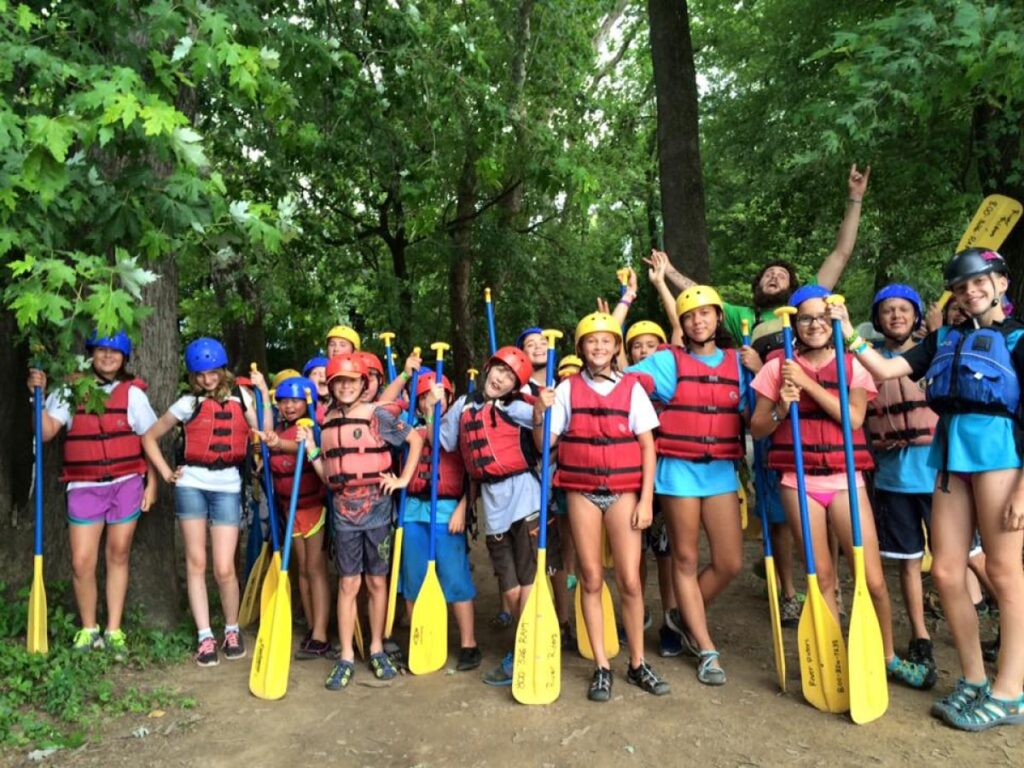 group of kids holding paddles while at the Outdoor Adventure Camp