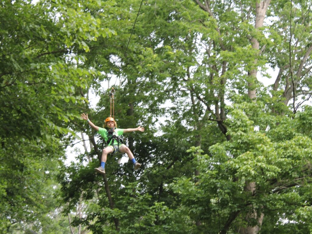 boy ziplining through the trees