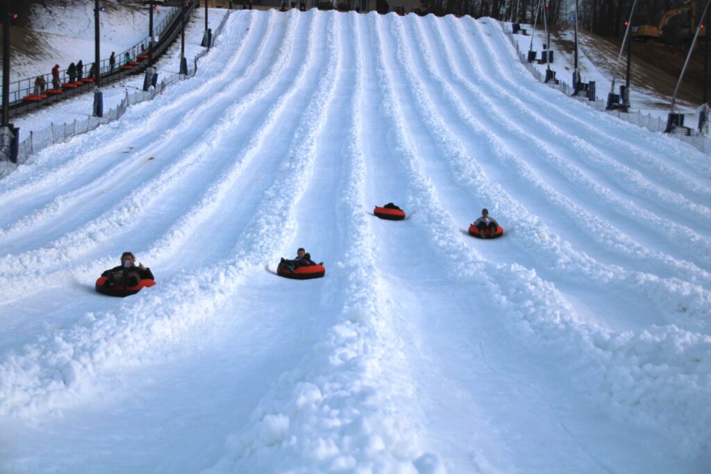 four people going down the Harpers Ferry snow tubing hill